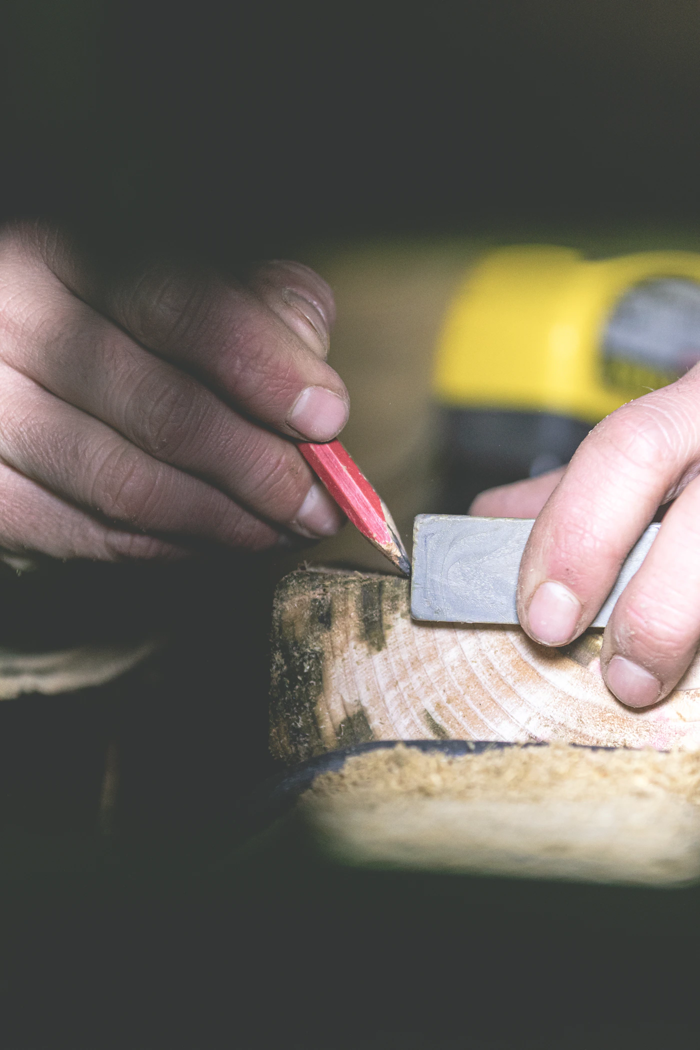 Carpenter marking timber with a pencil and square